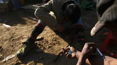 Dua penambang menyuntikkan heroin di Tambang batu giok di Hpakant, Myanmar, 29 November 2015. Kecanduan narkotika sudah merabak pada penambang batu giok untuk digunakan dengan alasan agar kuat mencari & menemukan gumpalan batu mulia (REUTERS/Soe Zeya Tun)