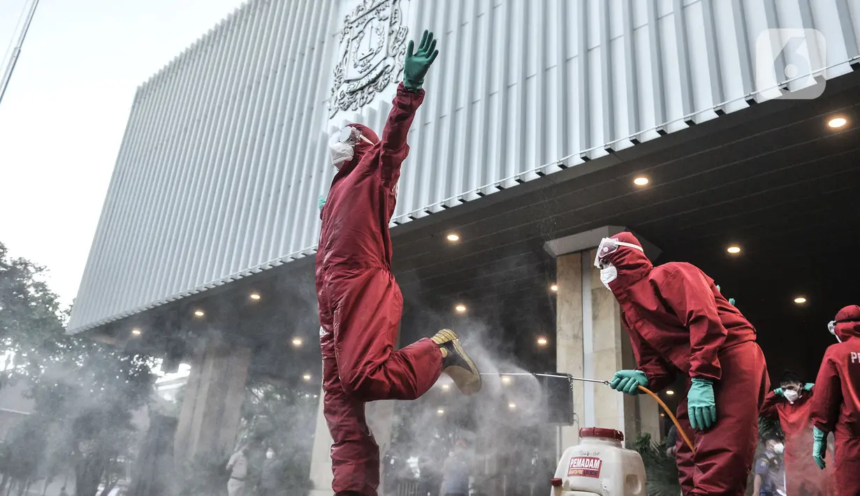 Petugas dari Sudin Gulkarmat Jakarta Pusat mensterilisasi rekan kerja usai melakukan penyemprotan di Balai Kota, Jakarta, Selasa (1/12/2020). (merdeka.com/Iqbal S. Nugroho)