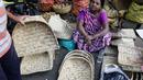 Seorang wanita menjual perlengkapan ibadah di sebuah kios pinggir jalan menjelang festival Hindu Chhath, di Kolkata, India (9/11/2021). Selama Chhath, festival Hindu kuno yang populer di kalangan kelas pekerja, ritual dilakukan untuk berterima kasih kepada Dewa Matahari. (AP Photo/Bikas Das)