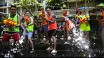 Sejumlah orang bersuka cita menggunakan pistol air saat perang air selama Festival Songkran di Silom Road, Bangkok, Jumat (13/4). Songkran dikenal sebagai festival air yang menandai dimulainya tahun baru tradisional Thailand. (LILLIAN SUWANRUMPHA/AFP)