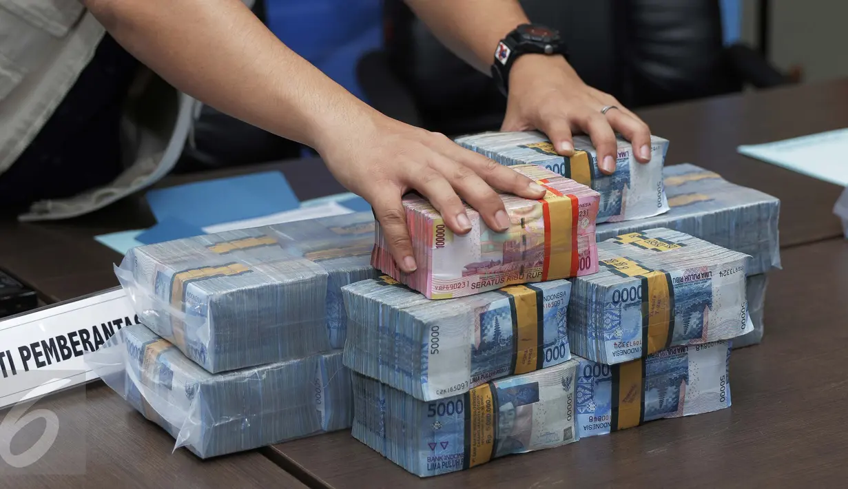 Petugas BNN menata barang bukti saat rilis kasus tindak pencucian uang di BNN, Jakarta, Kamis (24/11). BNN menyita aset senilai Rp 153 Miliar dari tersangka MI yang diduga melakukan pencucian uang hasil kejahatan narkoba. (Liputan6.com/Gempur M Surya)