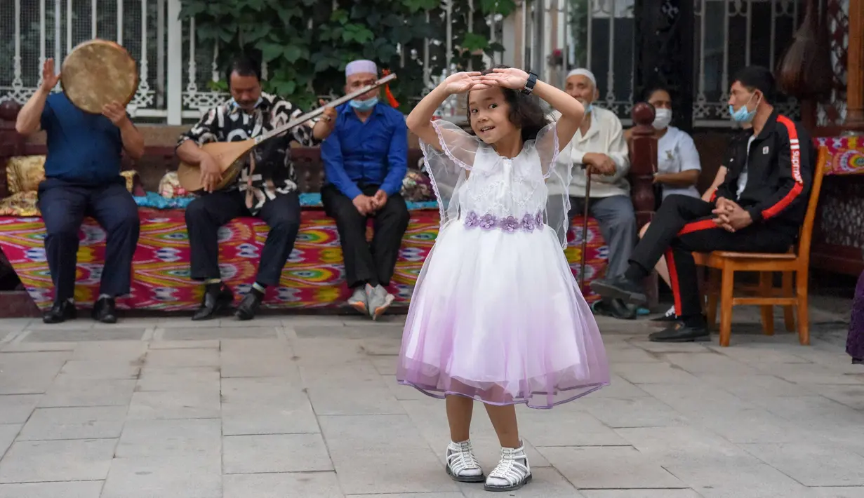 Seorang gadis kecil menari dengan iringan musik di Grand Bazaar Food Street di Urumqi, ibu kota Daerah Otonom Uighur Xinjiang, China barat laut, pada 4 Juli 2020. (Xinhua/Ding Lei)