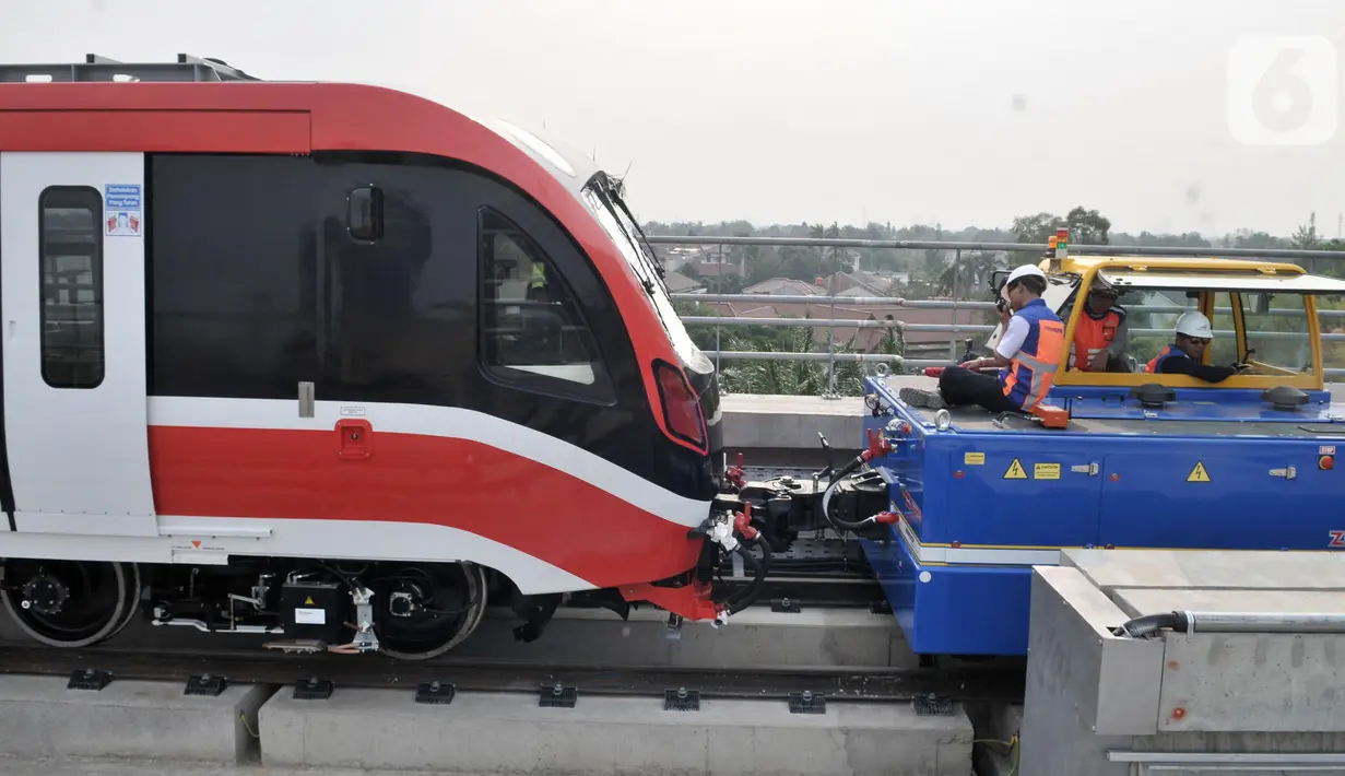 Pekerja menderek rangkaian kereta LRT Jabodebek yang baru tiba di Stasiun Harjamukti, Cibubur, Minggu (13/10/2019). Pengiriman prasarana gerbong LRT produksi PT INKA ke Jakarta dilakukan melalui jalur Tol Trans Jawa dan diangkut menggunakan multi-axle. (merdeka.com/Iqbal S Nugroho)