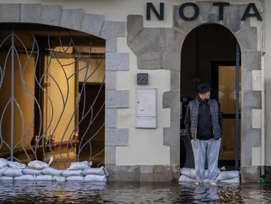 Seorang warga berdiri di jalan yang tergenang air di Quimper, Prancis Barat, pada 29 Oktober 2023. (Fred TANNEAU/AFP)