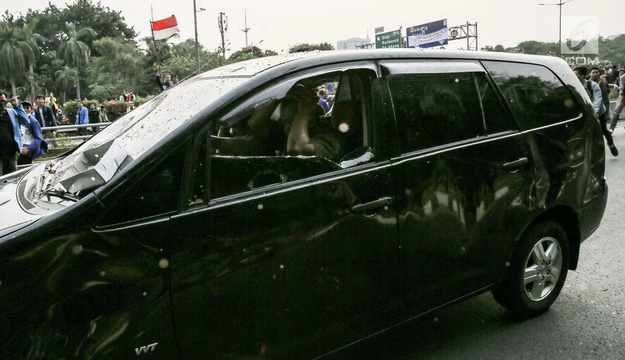 Massa aksi  melakukan penyerangan terhadap mobil pelat nomor merah yang melintasi jalan tol seberang Gedung DPR/ MPR RI, Jakarta, Selasa (24/9/2019). Selain menutup ruas tol, kendaraan dinas pemerintah dan milik polisi jadi korban pelemparan dan perusakan oleh mahasiswa. (Liputan6.com/Faizal Fanani)