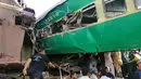 Tim penyelamat dan penduduk setempat berkumpul di dekat kecelakaan yang terjadi antara dua kereta di distrik Rahim Yar Khan, Pakistan, Kamis (11/7/2019). Insiden ini menyebabkan setidaknya sembilan orang tewas dan lebih dari 60 lainnya luka-luka. (Photo by STR / AFP)