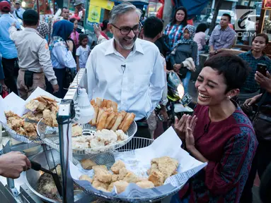 Dubes Inggris Moazzam Malik berbincang saat membeli gorengan untuk berbuka puasa di kawasan Museum Fatahilah, Jakarta, Minggu (18/6). Dalam kesempatan itu, Dubes Inggris untuk Indonesia Moazzam Malik bicara soal toleransi. (Liputan6.com/Gempur M Surya)