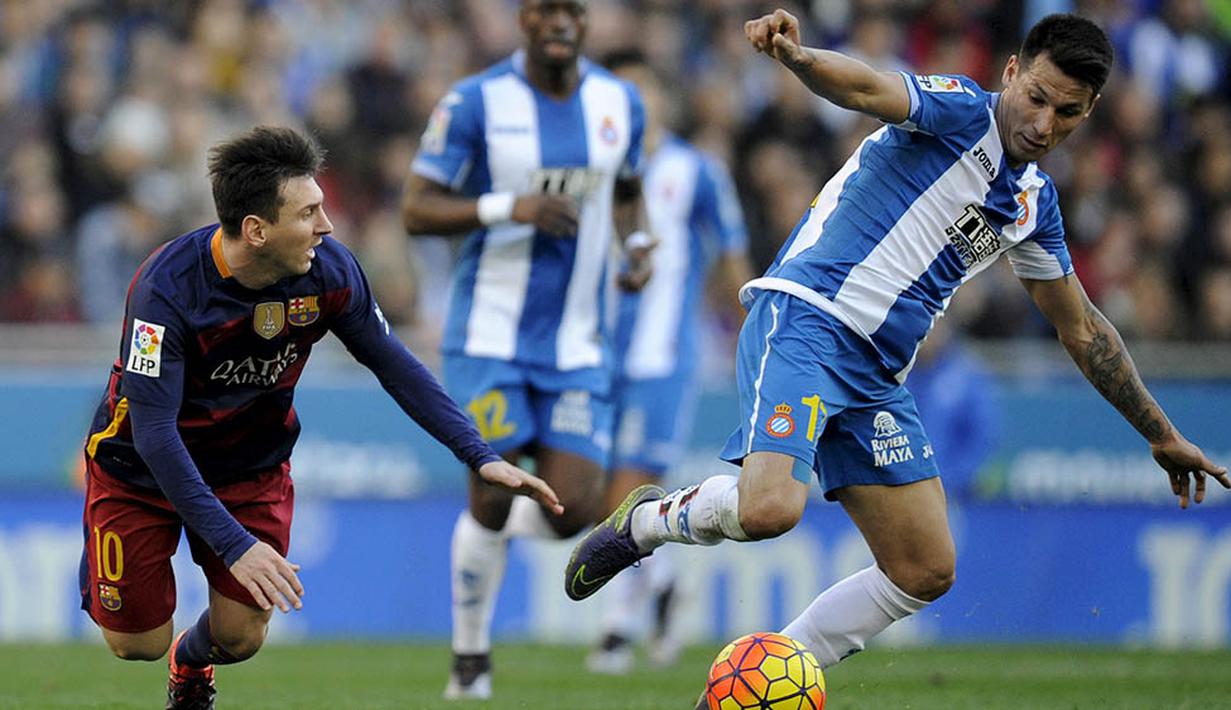 Pemain Barcelona, Lionel Messi, terjatuh saat berebut bola dengan pemain Espanyol, Hernan Perez, pada laga La Liga Spanyol. Trio Messi, Neymar dan Suarez gagal cetak gol, Barca hanya mampu bermain imbang. (Reuters/Stringer)