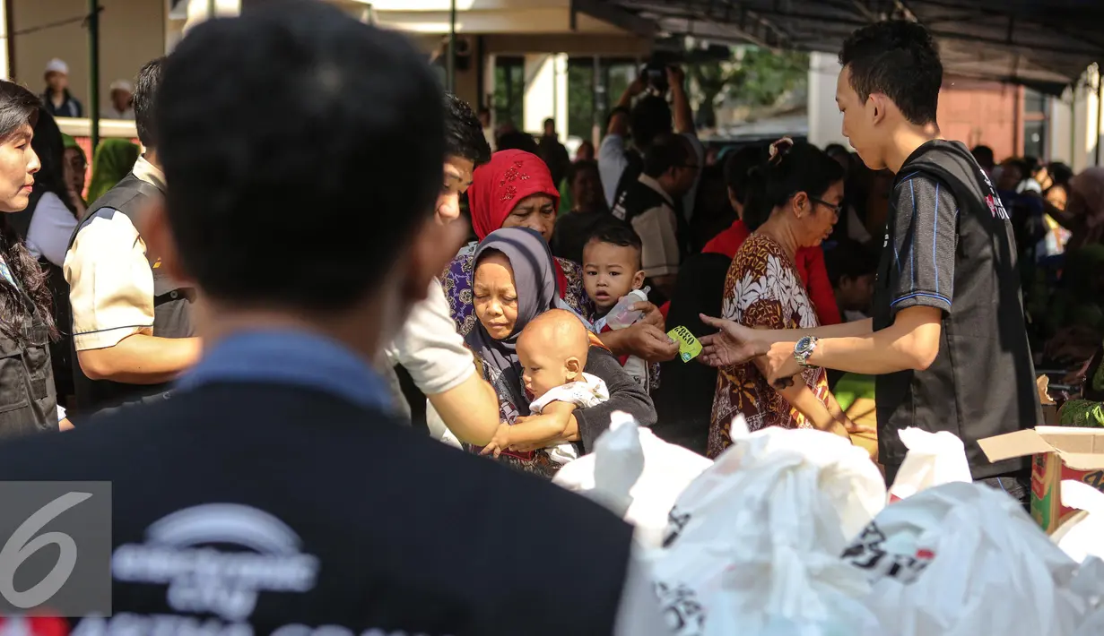 Petugas pasar murah melayani warga saat gelaran Pasar Murah Ramadan di Mesjid Jami Luar Batang, Jakarta, Kamis (9/7/2015). Pasar Murah Ramadan dimulai dari 29 Juni - 16 Juli 2015. (Liputan6.com/Faizal Fanani)