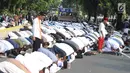 Massa pendukung pasangan capres-cawapres Prabowo Subianto dan Sandiaga Uno melakukan salat asar di Jalan Medan Merdeka Barat, Jakarta, Kamis (27/6/2019). Aksi tersebut dilakukan jelang putusan perselisihan hasil pemilihan umum (PHPU) Pilpres 2019 di Gedung MK. (merdeka.com/Arie Basuki)