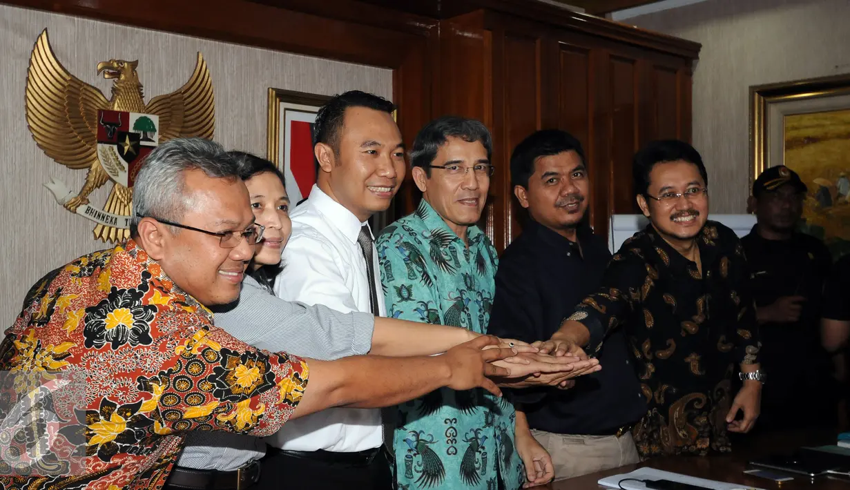 Komisioner KPU menyatukan tangan usai memberi keterangan terpilihnya Hadar Nafis Gumay sebagai Plt Ketua KPU Pusat di Jakarta, Selasa (12/7). Hadar terpilih melalui rapat pleno yang dilakukan secara tertutup. (Liputan6.com/Helmi Fithriansyah)