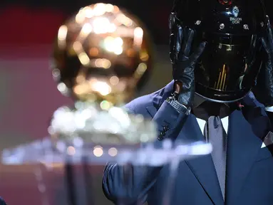 Dua pria yang mengenakan helm seperti gaya duo musisi elktronik asal Prancis, Daft Punk terlihat memasuki acara penyerahan penghargaan Ballon d'Or 2021. Mereka berjalan di antara para undangan sambil membawa trofi Ballon d'Or. (AFP/Franck Fife)