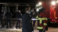 Petugas pemadam kebakaran berbicara satu sama lain berdiri di dekat rumah sakit darurat yang terbakar di kota Tetovo, Makedonia Utara, Kamis (9/9/2021). Kebakaran terjadi Rabu malam di rumah sakit darurat untuk pasien COVID-19. (AP Photo/Boris Grdanoski)