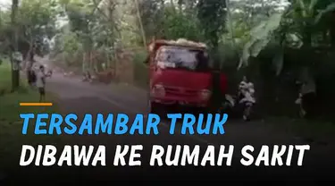 Ketika truk berwarna merah melintas, bokong truk itu mengenai salah satu perekam video.