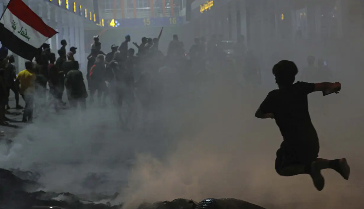 Para pengunjuk rasa ikut serta dalam protes anti-pemerintah menuntut pemilihan umum yang bebas dan melawan korupsi di luar gedung dewan provinsi di Basra, Irak, 17 Agustus 2020. (AP Photo / Nabil al-Jurani)