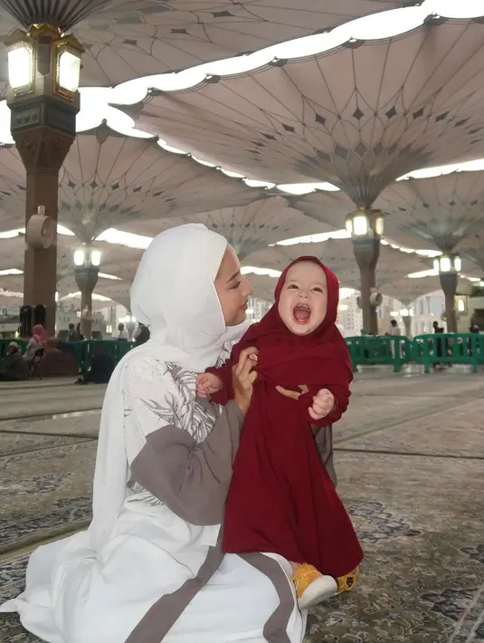 Potret lain yang tak kalah mencuri atensi, memperlihatkan Jennifer yang tampil menawan kenakan abaya kombinasi warna brown-white. Abaya dengan detail motif dedaunan itu dipadukan dengan  pashmina dan ciput warna putih.[@jennifercoppenreal20].