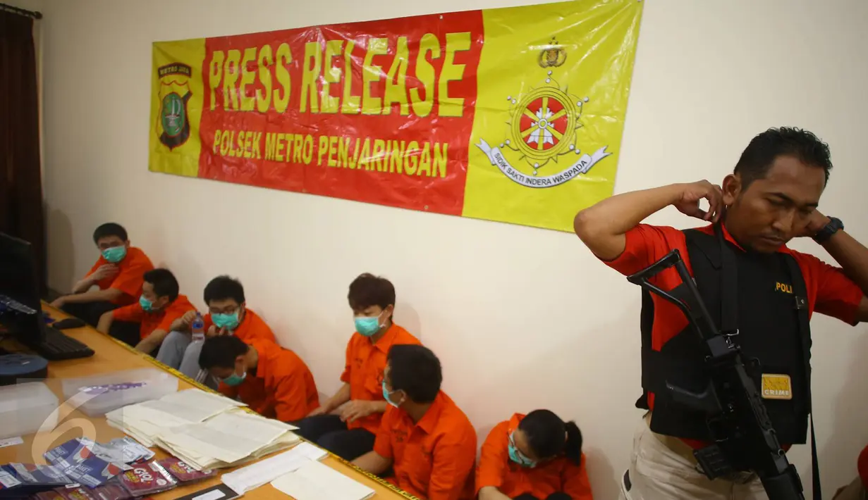 Petugas menunjukkan tersangka beserta barang bukti kasus tindak pidana keimigrasian penyalahgunaan izin tinggal di Komplek Katamaran, Kapuk Muara, Jakarta, Selasa (24/1). (Liputan6.com/ Immanuel Antonius)
