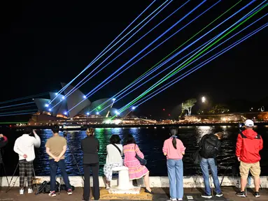 Sinar laser menerangi layar Sydney Opera House saat selama perayaan untuk menandai ulang tahunnya ke-50, Jumat (20/10/2023). (Saeed KHAN / AFP)