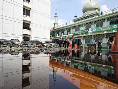 Petugas saat memusnahkan belasan ribu botol minuman keras berbagai merek dan belasan ribu gram ganja kering siap edar di halaman Mapolres Metro Jakarta Selatan, Kamis (2/6). (Liputan6.com/Immanuel Antonius)