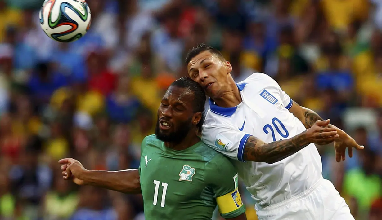 Pemain depan Pantai Gading, Didier Drogba (kiri), berebut bola dengan bek Yunani, Jose Holebas, di laga penutup penyisihan Piala Dunia 2014 Grup C di Stadion Castelao, Fortaleza, Brasil, (25/6/2014). (REUTERS/Eddie Keogh)