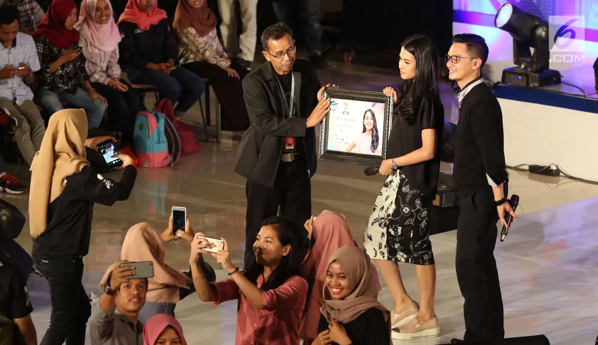 Artis Maudy Ayunda menerima cendramata di EGTC 2017 di Universitas Gadjah Mada, Yogyakarta, Rabu (1/11). EGTC 2017 menghadirkan tokoh-tokoh inspiratif bertujuan agar para mahasiswa memperoleh pengalaman dan wawasan baru. (Liputan6.com/Helmi Afandi)