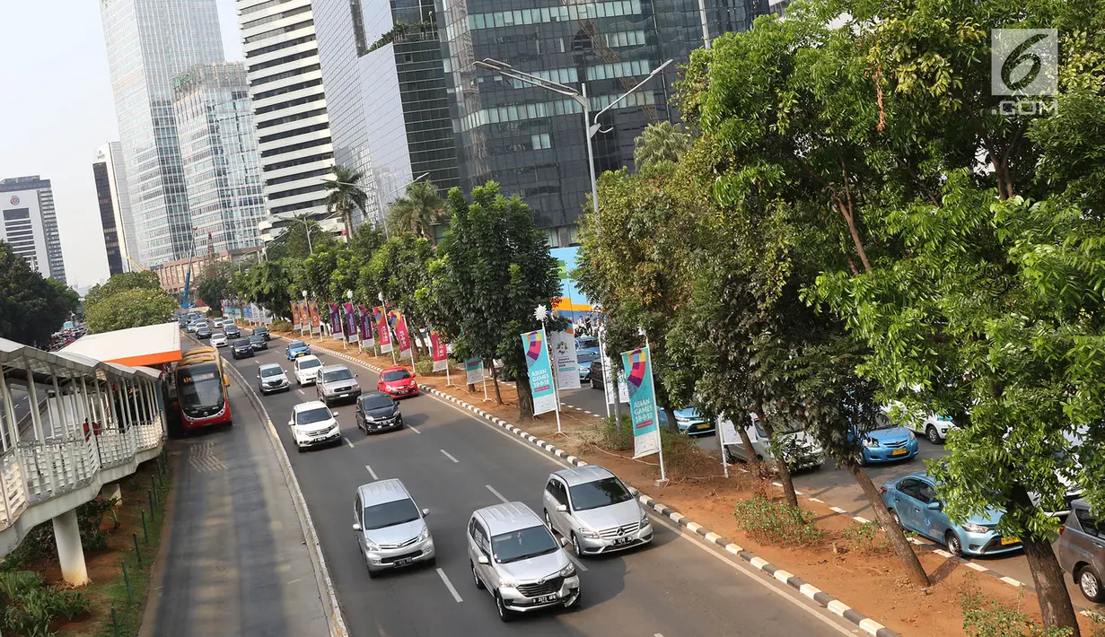 Kendaraan melintas di Jalan Sudirman, Jakarta, Selasa (19/9). Terkait pembangunan trotoar, Sekda DKI Saefullah mengatakan ribuan pohon akan dipindahkan ke lokasi yang merupakan aset Pemprov DKI, seperti Taman BMW. (Liputan6.com/Immanuel Antonius)
