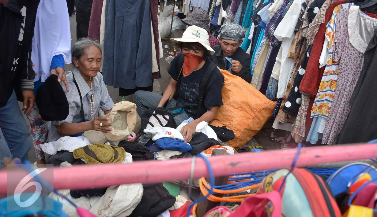 Calon pembeli melihat barang dagangan di depan gedung Pasar Senen, Jakarta, Minggu (22/1). Pasca kebakaran tidak membuat para pedangang putus asa, sebagian dari mereka tetap berjualan meskipun harus di bahu jalan. (Liputan6.com/Helmi Affandi)