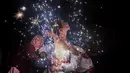 Seorang pria bermandinkan percikan kembang api saat mengikuti ritual eating flowers di provinsi Fujians, China (16/2). Ritual unik ini digelar untuk mengusir roh-roh jahat. (AFP/Johannes Eisele)
