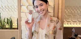Maudy Ayunda memegang serum terbaru dari From This Island  berbahan dasar kunyit. [Anisha/Fimela]