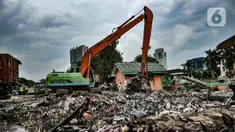 Petugas UPK Badan Air DLH Provinsi DKI Jakarta mengangkut sampah sungai memakai alat berat di TPSS Perintis Kemerdekaan, Jakarta, Selasa (16/2/2021). Selama musim hujan, volume sampah yang diangkut dari sungai di Jakarta meningkat hingga 600 meter kubik per hari. (merdeka.com/Iqbal S. Nugroho)