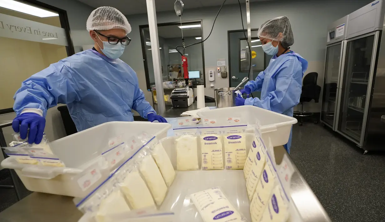 <p>Teknisi lab susu Welney Huang (kanan) dan Nguyen Nguyen, memproses ASI di University of California Health Milk Bank, San Diego, Jumat (13/5/2022). Kelangkaan susu formula bayi di Amerika Serikat telah memicu gelombang minat di kalangan ibu yang ingin menyumbangkan ASI untuk membantu menjembatani kesenjangan pasokan serta mereka yang ingin bayi mereka tetap makan. (AP Photo/Gregory Bull)</p>
