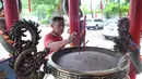 Petugas membersihkan tempat menaruh hio di Vihara Amurva Bhumi, Jakarta, Sabtu (14/02/2015). Menjelang imlek sejumlah kelenteng mulai dipercantik (Liputan6.com/Andrian M Tunay)