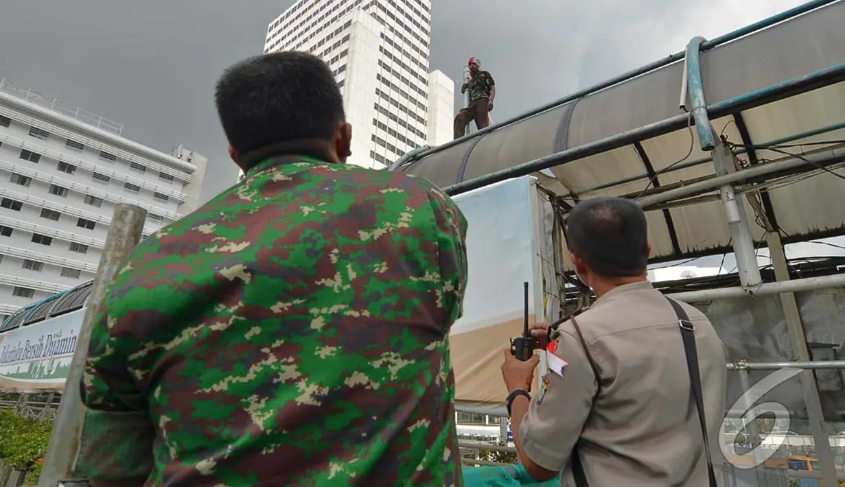 Petugas berusaha membujuk Agustinus untuk menghentikan aksi berbahayanya, Jakarta, Rabu (23/07/2014) (Liputan6.com/Johan Tallo)