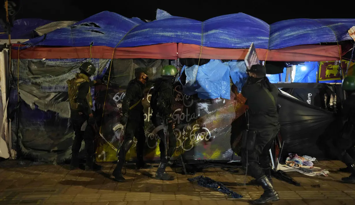 Militer Sri Lanka melepaskan tenda dari lokasi kamp protes anti-pemerintah di luar Sekretariat Presiden di Kolombo, Sri Lanka, Jumat (22/7/2022). Personel keamanan yang bersenjatakan pentungan mulai mencopot barikade yang didirikan pengunjuk rasa untuk menghalangi gerbang utama Sekretariat Presiden yang sebagian telah mereka kuasai awal Juli 2022. (AP Photo/Rafiq Maqbool)