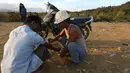 Seorang penambang membantu temannya menyuntikan heroin pada tubuhnya di Tambang batu giok di Hpakant, Myanmar, 29 November 2015. Kecanduan narkotika sudah merabak pada penambang batu giok. (REUTERS/Soe Zeya Tun)