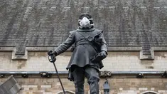 Sebuah masker terpasang pada wajah patung Oliver Cromwell di luar Gedung Parlemen di London, Senin (18/4). Aksi yang dilakukan oleh aktivis lingkungan Greenpeace itu untuk memprotes kualitas polusi udara di kawasan tersebut. (Leon NEAL/AFP)