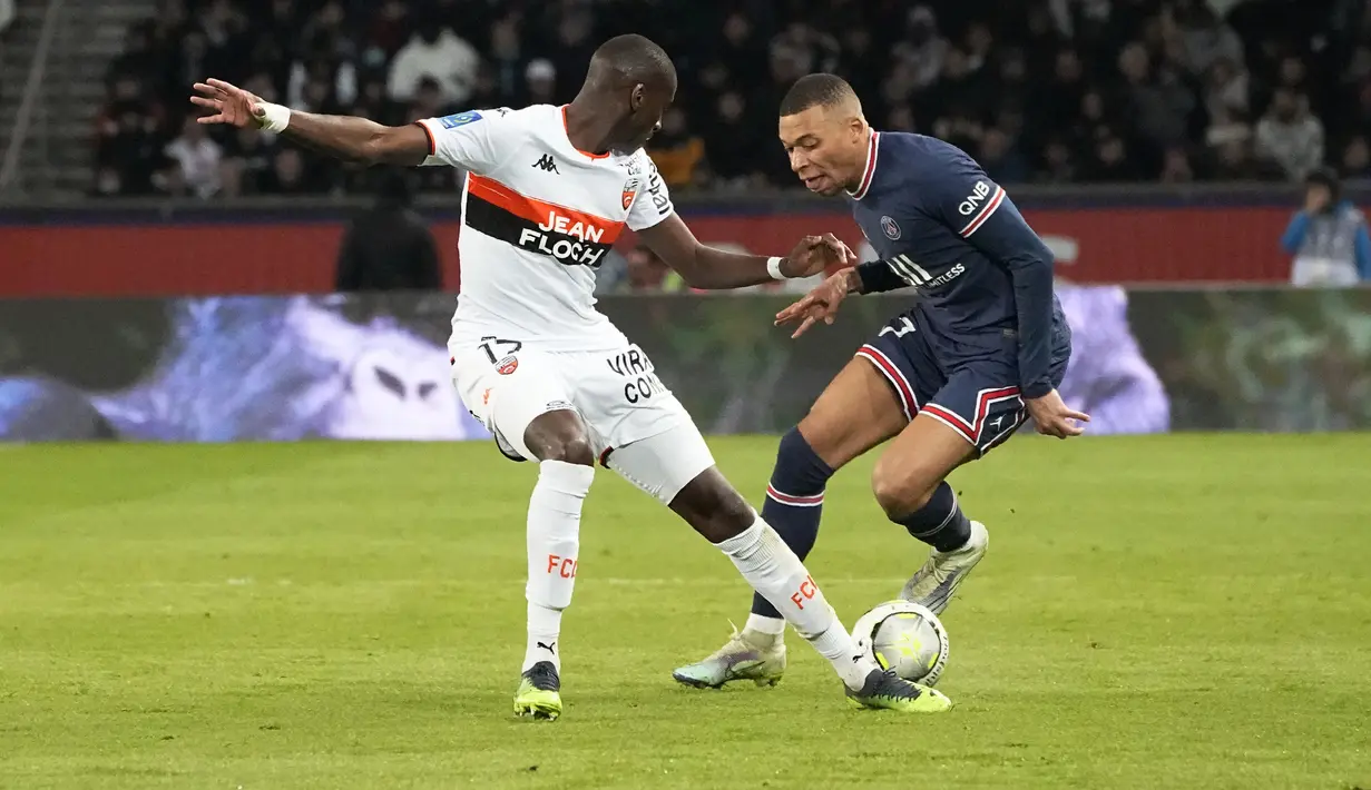 Penyerang PSG, Kylian Mbappe berusaha melewati pemain Lorient, Houboulang Mendes pada pertandingan lanjutan Liga 1 Prancis di stadion Parc des Princes di Paris, Senin (4/4/2022). Hasil ini membuat PSG mengumpulkan 68 poin dari 30 pertandingan. (AP Photo/Michel Euler)