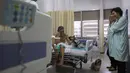 Seorang pasien bernama Nivaldo Lopes (60) duduk bersama anjing peliharaan bernama Paola di tempat tidurnya di Rumah Sakit Dukungan Brazil.(24/11/2016). Terapi hewan peliharaan merupakan program rumah sakit yang sedang digalakan. (AP Photo / Eraldo Peres)