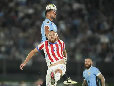 Bek Uruguay Sebastian Caceres menyundul bola melewati penyerang Paraguay Isidro Pitta pada matchday 7 Kualifikasi Piala Dunia 2026 zona CONMEBOL. Laga ini berlangsung di Estadio Centenario, Sabtu (7/9/2024) pagi WIB. (AP Photo/Matilde Campodonico)