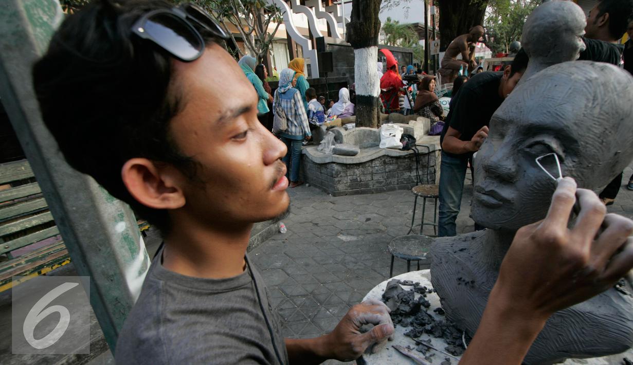 Pematung mendemonstrasikan karyanya  pada Jogja Street Sculpture Project di Jalan Mangkubumi , (30/10/15).Sejumlah karya seni patung di paang di ruang publik yang di ikuti oleh 32 pematung. (Foto /Boy T Harjanto)