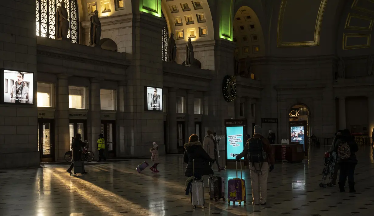 Orang-orang tiba di stasiun kereta Union Station di Washington, DC, Kamis (23/12/2021). Jutaan orang Amerika bepergian pada 23 Desember 2021, selama salah satu hari perjalanan tersibuk di musim liburan, ketika infeksi Covid dengan Omicron melampaui puncak gelombang varian Delta. (Pedro Ugarte/AFP)