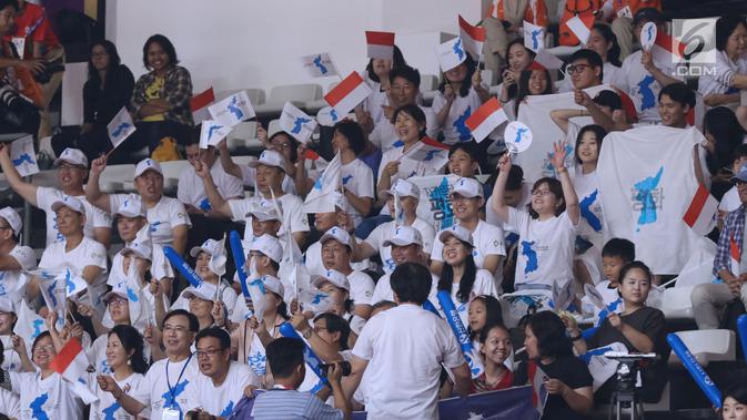 Pendukung tim Korea ikut mengibarkan bendera Merah Putih saat menyaksikan laga putri Indonesia melawan Korea pada babak penyisihan Grup X Basket Putri Asian Games 2018 di Jakarta, Rabu (15/8). Indonesia kalah 40-108. (Liputan6.com/Helmi Fithriansyah)