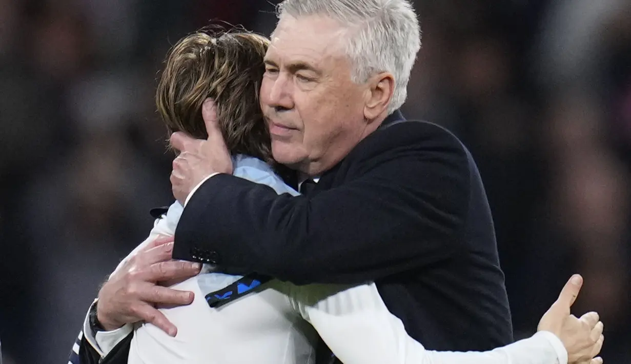 Pemain Real Madrid, Luka Modric berpelukan dengan pelatih Carlo Ancelotti setelah laga lanjutan Liga Spanyol 2023/2024 melawan Sevilla di Stadion Santiago Bernabeu, Madrid, Spanyol, Senin (26/02/2024) dini hari WIB. Los Blancos menang dengan skor 1-0. (AP Photo/Manu Fernandez)