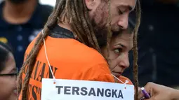 Pasangan kekasih berkewarganegaraan Australia dan Inggris Sara Cannor dan David James Taylor saling berpelukan selama proses rekonstruksi kasus pembunuhan polisi, Aipda Wayan Sudarsa, di Pantai Legian, Kuta, Rabu (31/8). (AFP PHOTO / SONNY Tumbelaka)