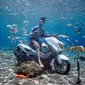 Pengunjung berfoto di atas sepeda motor dalam kolam renang Umbul Ponggok, Desa Polanharjo, Klaten, Jawa Tengah, Minggu (30/9). Selain sepeda motor, kolam renang ini juga berisi ikan, bebatuan, dan properti lainnya. (Liputan6.com/Gholib)