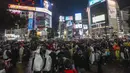 Penonton Halloween berjalan-jalan dengan kostum saat ribuan orang berkumpul di distrik Shibuya, area berkumpul yang populer untuk Halloween, Minggu (31/10/2021). Daerah di sekitar Stasiun Shibuya dipadati anak-anak muda yang berdandan selama Halloween setiap tahun. (AP Photo /Kiichiro Sato)