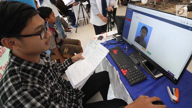 Petugas Disdukcapil Kota Tangerang Selatan melakukan perekaman data untuk pembuatan Kartu Identitas Anak (KIA) di mal Living Wolrd Alam Sutera, Serpong, Senin (17/12). Pusat perbelanjaan ini menggelar pembuatan KIA secara gratis. (Merdeka.com/Demy)