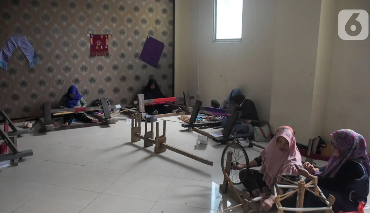 Warga mengikuti pelatihan pembuatan kain tenun motif Betawi di Rusunawa Jatinegara, Jakarta, Rabu (13/11/2019). Pemerintah akan memprioritaskan penyaluran KUR kelompok, seiring dengan diturunkannya suku bunga KUR per 1 Januari 2020 menjadi 6 persen, dari  7 persen. (Liputan6.com/Angga Yuniar)