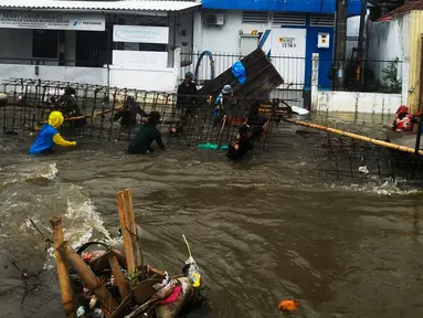 Pekerja membuat penahan tanggul jebol saat banjir merendam Perumahan Taman Mangu Indah, Jurangmangu Barat, Pondok Aren, Tangerang Selatan, Banten, Selasa (12/11/2024). (merdeka.com/Arie Basuki)