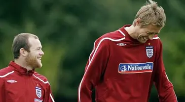 Wayne Rooney and Peter Crouch share a joke as they walk to the training ground for training at London Colney, North London, on October 7, 2008. AFP PHOTO/Glyn Kirk